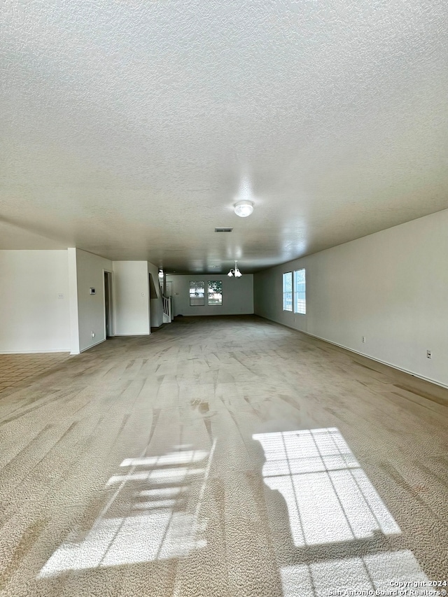 interior space featuring light carpet and a textured ceiling