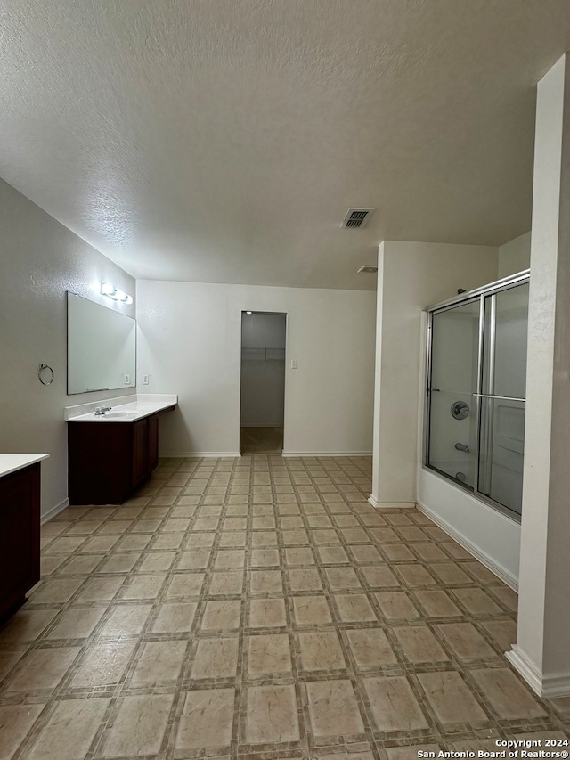 bathroom with tile patterned floors, vanity, and a textured ceiling