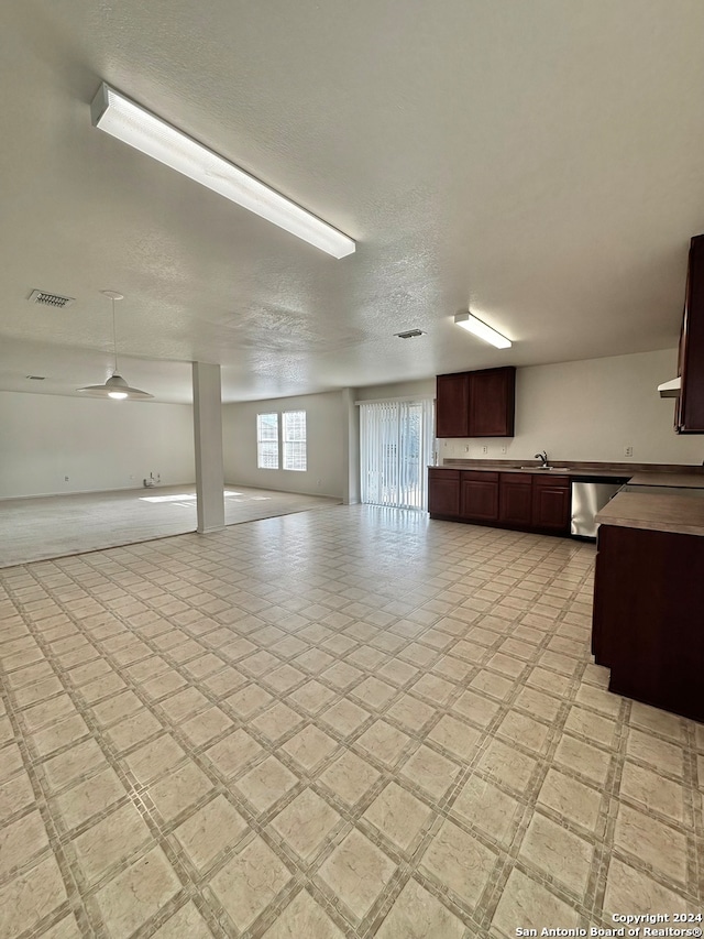 interior space featuring a textured ceiling, sink, light tile patterned floors, and ceiling fan