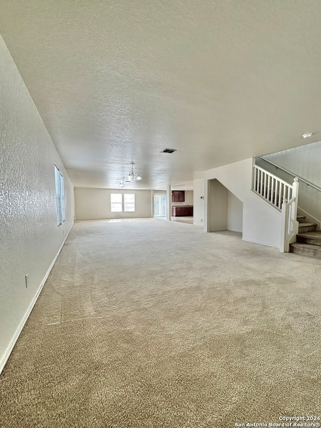 unfurnished living room featuring carpet floors and a textured ceiling