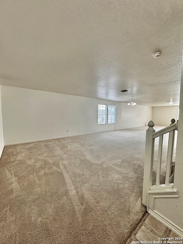 empty room with carpet flooring and a textured ceiling