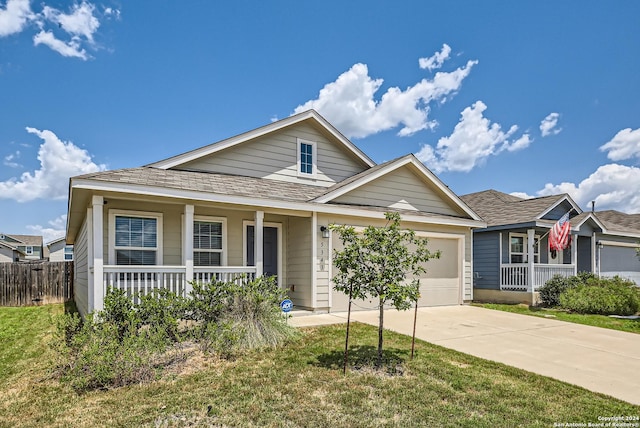 view of front of home with a garage, covered porch, and a front lawn