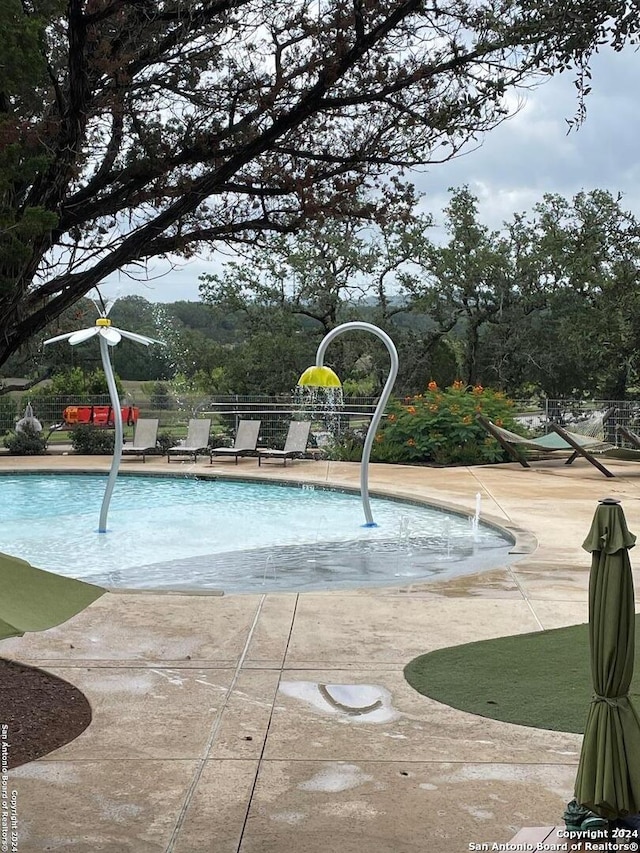 view of pool with a patio and pool water feature