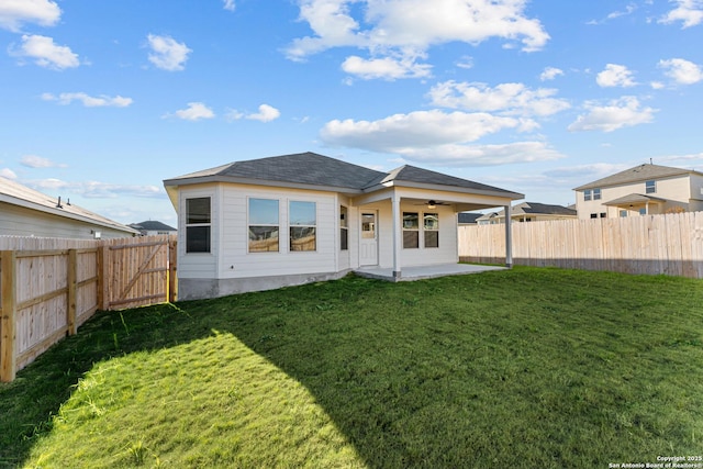 back of house featuring ceiling fan, a patio, and a yard