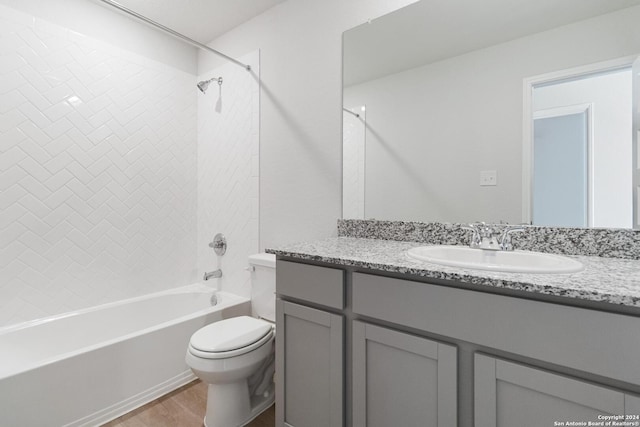 full bathroom featuring hardwood / wood-style flooring, vanity, toilet, and tiled shower / bath combo