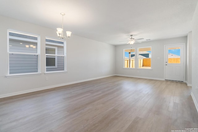 unfurnished room featuring ceiling fan with notable chandelier and light hardwood / wood-style floors