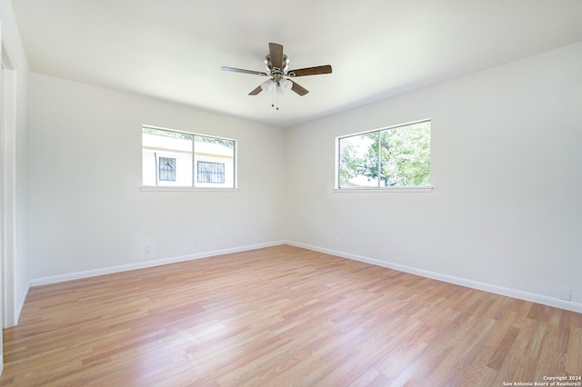 empty room with ceiling fan, a healthy amount of sunlight, and light hardwood / wood-style flooring