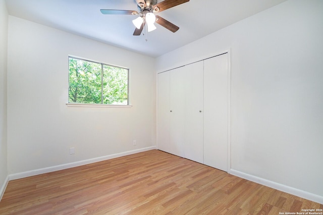 unfurnished bedroom featuring ceiling fan, light wood-type flooring, and a closet