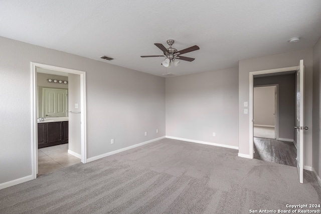 spare room featuring sink, light carpet, and ceiling fan