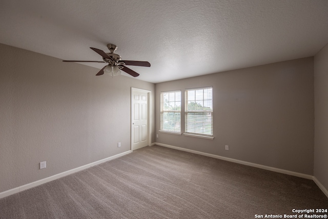 carpeted spare room with a textured ceiling and ceiling fan