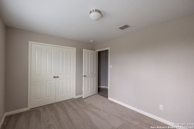 unfurnished bedroom featuring carpet and a closet