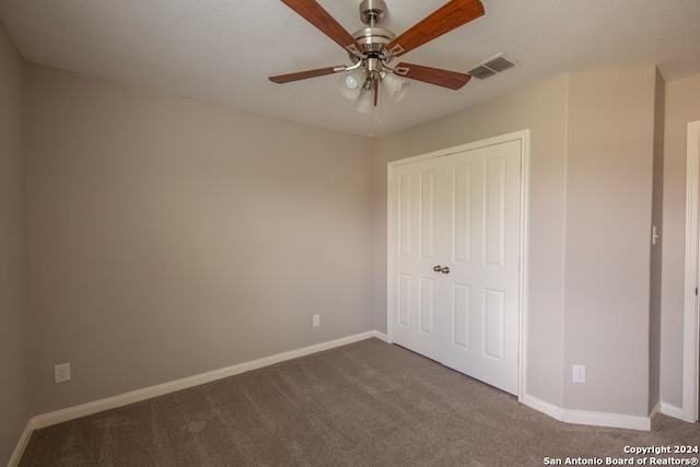 unfurnished bedroom with carpet floors, ceiling fan, and a closet