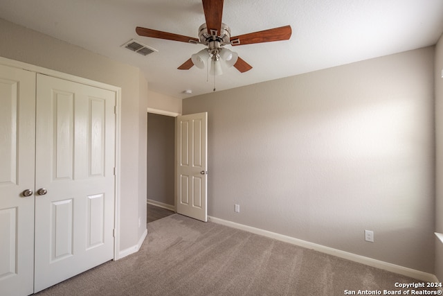 unfurnished bedroom featuring ceiling fan, carpet, and a closet