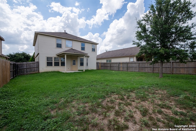 rear view of house featuring a yard