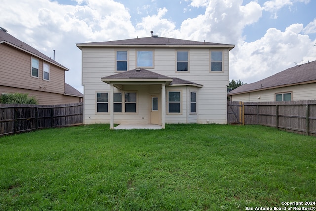 rear view of property with a yard and a patio