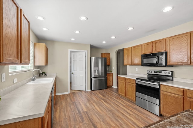 kitchen with sink, hardwood / wood-style flooring, and stainless steel appliances