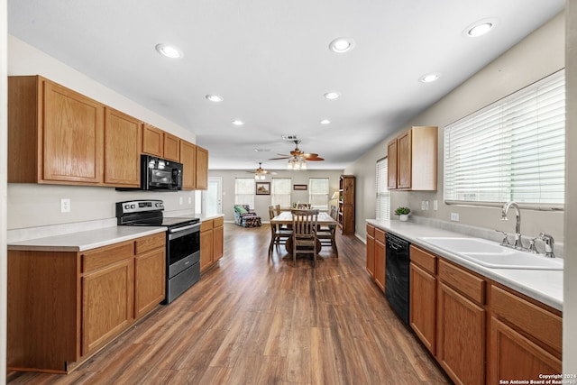 kitchen featuring dark wood-type flooring, sink, ceiling fan, and black appliances