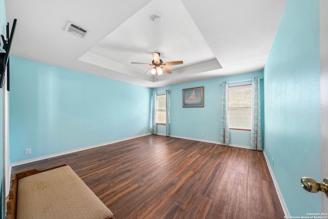 spare room with hardwood / wood-style floors, plenty of natural light, and a raised ceiling