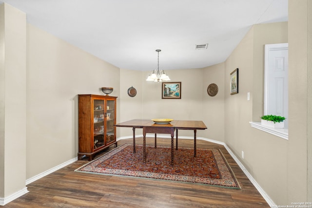 dining room with dark hardwood / wood-style floors and a chandelier