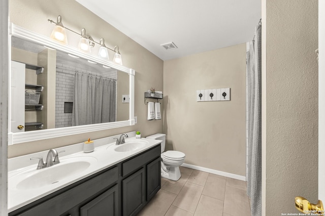 bathroom featuring tile patterned flooring, toilet, and dual bowl vanity