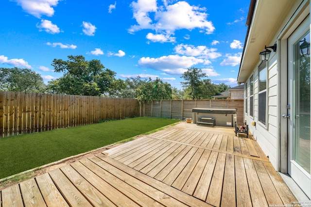 wooden terrace featuring a lawn and a hot tub