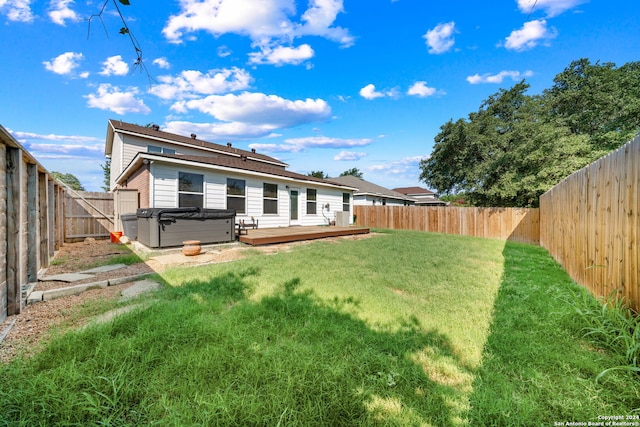 rear view of property featuring a yard and a wooden deck