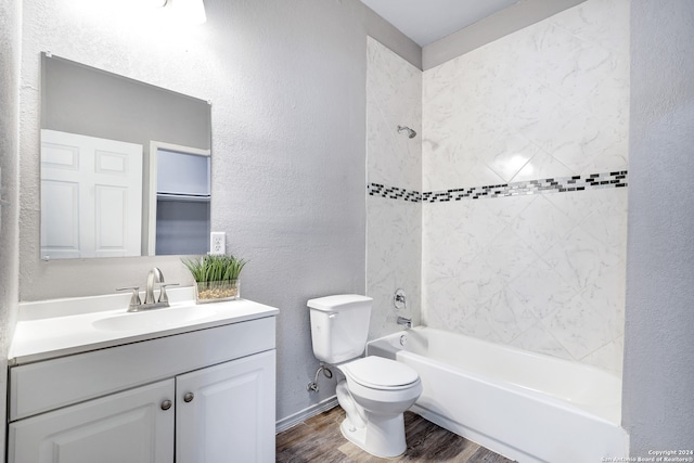 full bathroom with tiled shower / bath combo, vanity, wood-type flooring, and toilet