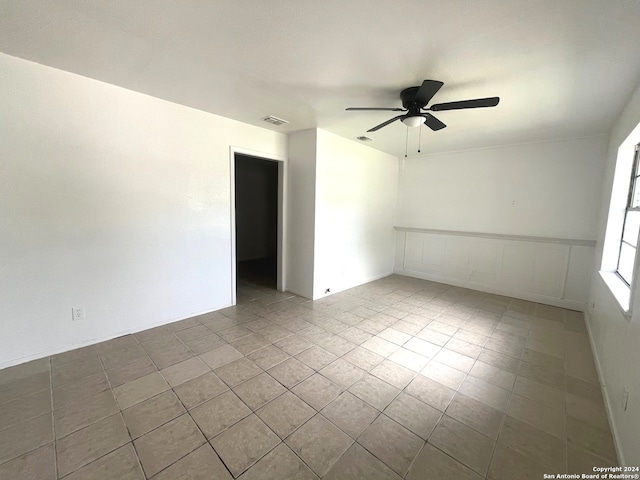 tiled empty room featuring ceiling fan