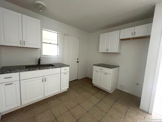 2205 Louise St, Seguin, TX 78155 - kitchen featuring dark stone countertops, a sink, and white cabinetry