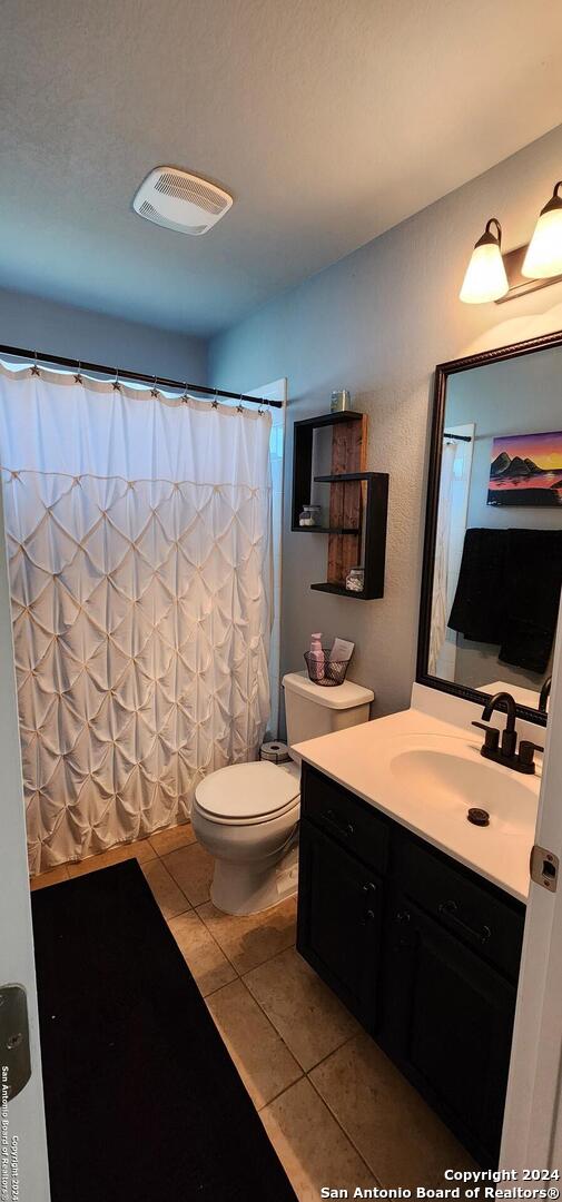 bathroom featuring tile patterned flooring, vanity, and toilet