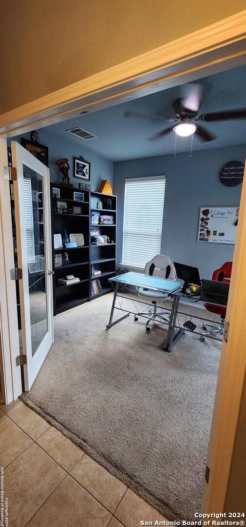 home office featuring tile patterned flooring and ceiling fan