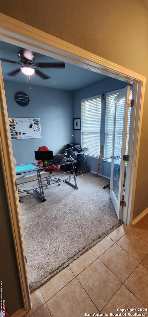 interior space featuring light carpet and ceiling fan