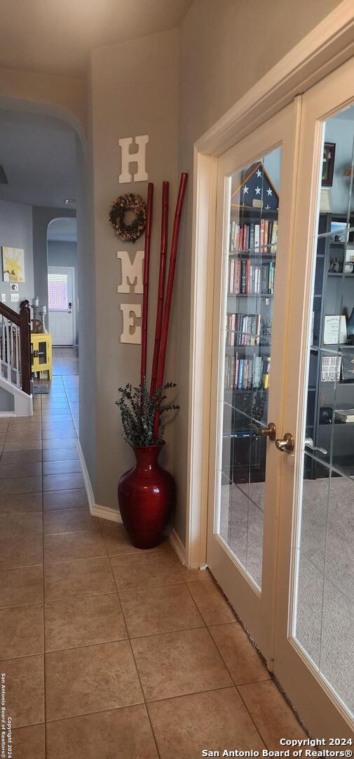 hallway featuring tile patterned flooring and french doors