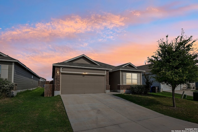 ranch-style home with a garage and a lawn