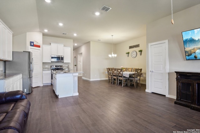 kitchen featuring appliances with stainless steel finishes, dark hardwood / wood-style floors, white cabinets, and a center island with sink