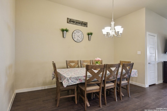 dining area with dark hardwood / wood-style flooring and an inviting chandelier