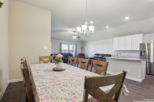 dining room featuring dark wood-type flooring, ceiling fan with notable chandelier, and sink