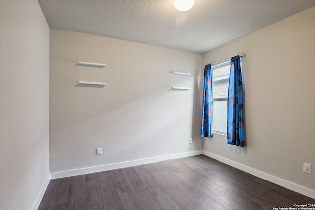 empty room with hardwood / wood-style floors and a textured ceiling