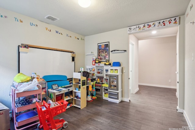 game room with a textured ceiling and hardwood / wood-style floors