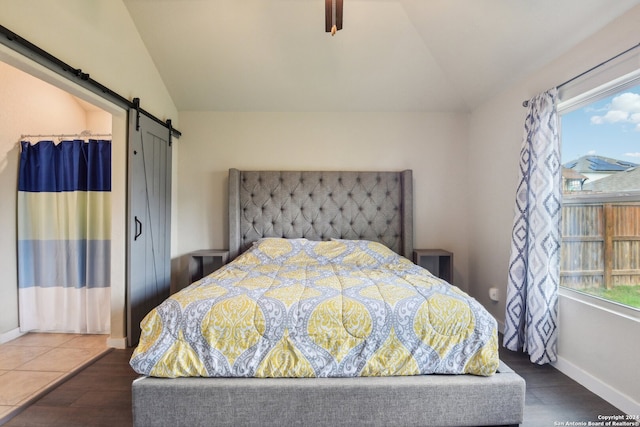 bedroom featuring dark hardwood / wood-style floors, multiple windows, and a barn door