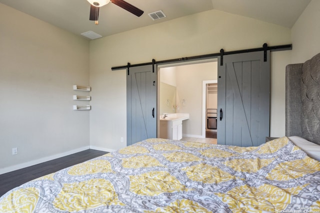 bedroom with lofted ceiling, a barn door, ceiling fan, hardwood / wood-style flooring, and ensuite bath