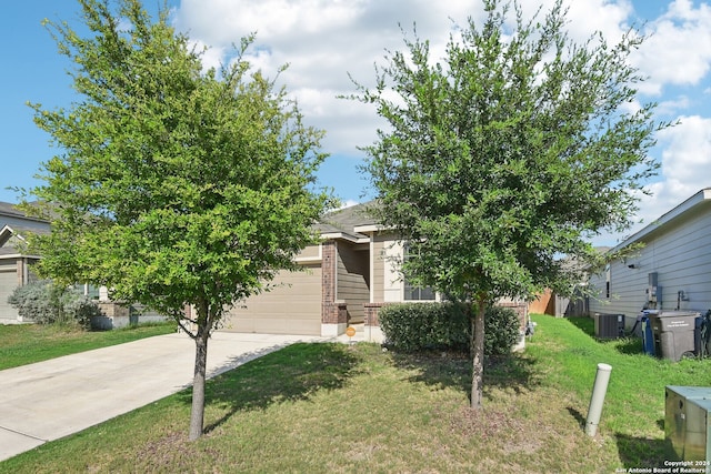 obstructed view of property with a garage, central AC, and a front lawn