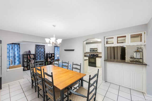 dining area featuring light tile patterned flooring and a chandelier