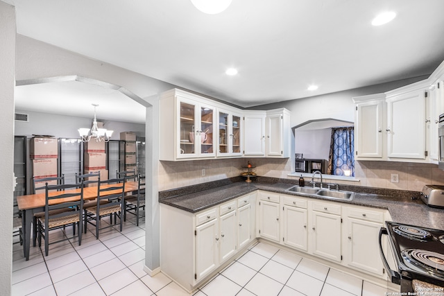 kitchen featuring decorative backsplash, sink, white cabinets, and light tile patterned floors