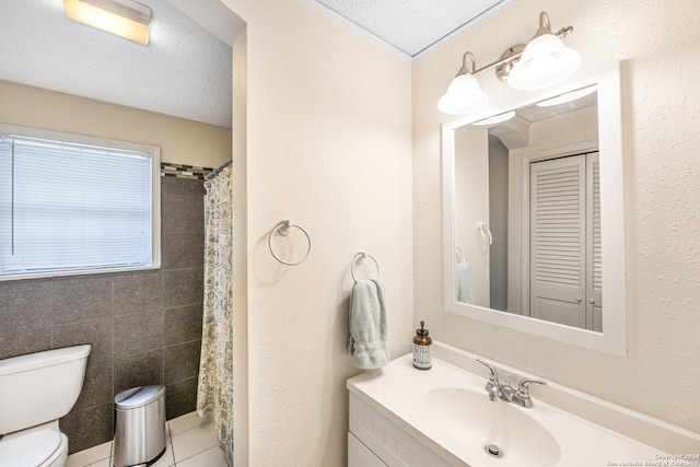 bathroom featuring tile walls, a textured ceiling, tile patterned floors, toilet, and vanity