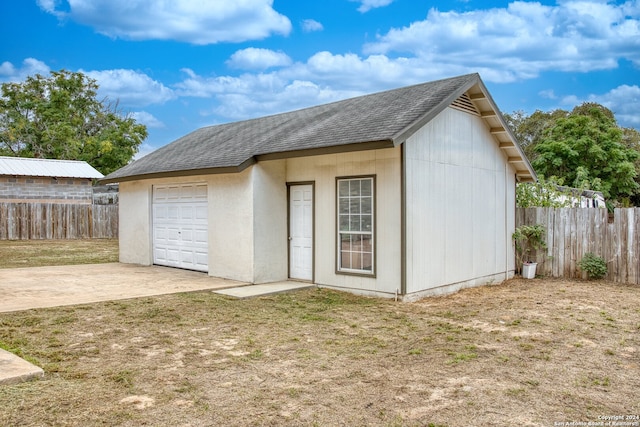 view of outdoor structure with a garage and a lawn