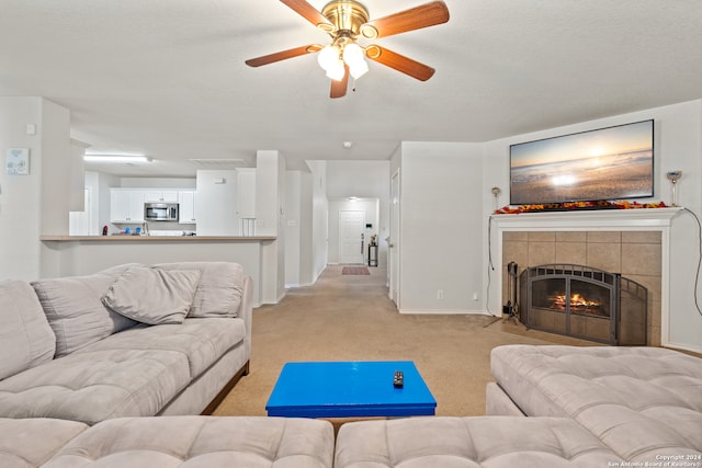 carpeted living room with a fireplace, a textured ceiling, and ceiling fan