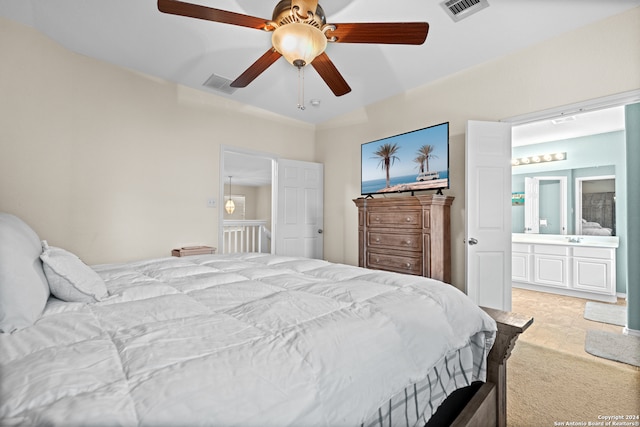 bedroom featuring ceiling fan, connected bathroom, and light colored carpet