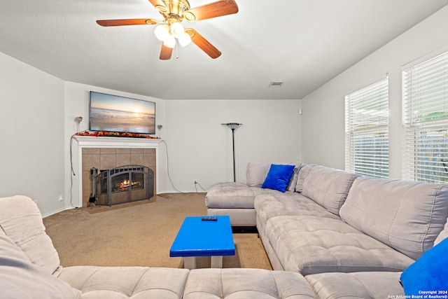 carpeted living room featuring a fireplace and ceiling fan