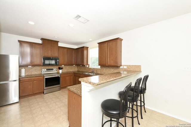 kitchen with tasteful backsplash, stainless steel refrigerator, light tile patterned floors, and electric stove